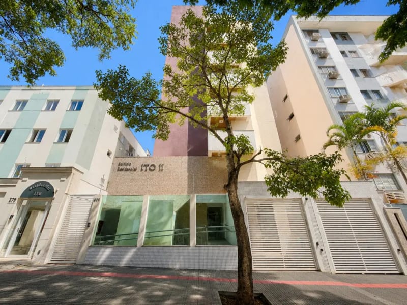 Fachada de um edifício residencial em Maringá, com árvore na calçada e céu azul
