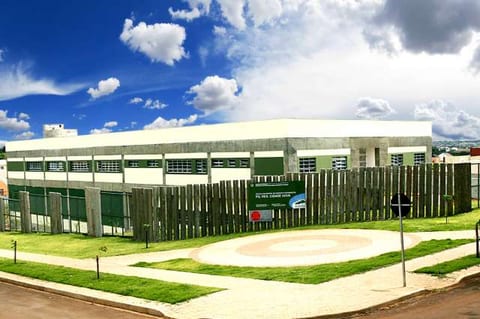 Prédio de uma escola pública municipal de Maringá, no Parque Residencial Cidade Nova, com gramado na frente e céu azul